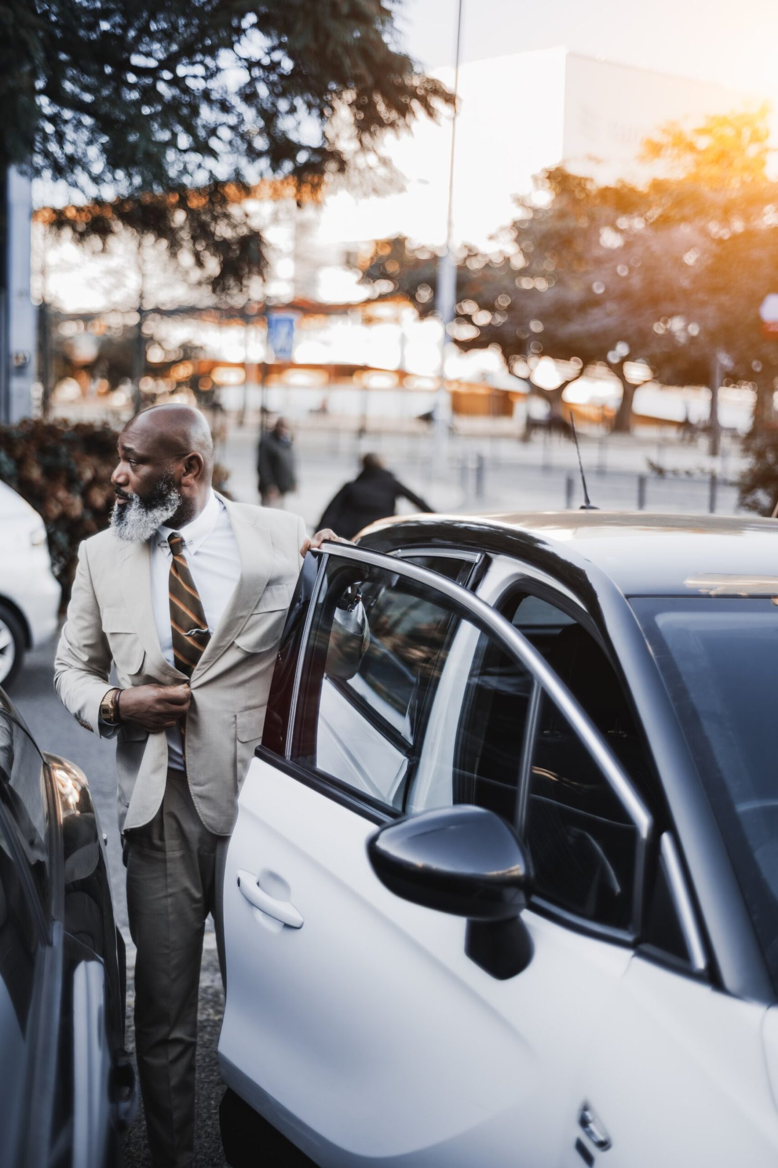 Businessman exiting a luxury car, representing Top Class Chauffeurs' professional chauffeur service