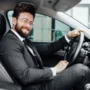 handsome young businessman full suit smiling while driving new car 90x90