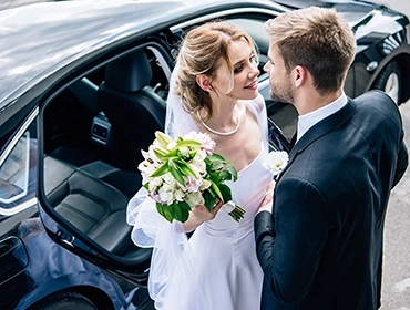 Bride and groom with elegant wedding car | Top Class Chauffeurs, wedding limo, luxury transportation