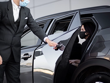 Chauffeur opening car door for client - Top Class Chauffeurs, luxury transportation, professional chauffeur service